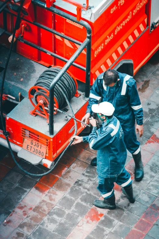 a couple of men standing next to a fire truck, pexels contest winner, figuration libre, working clothes, a high angle shot, hoses:10, profile image