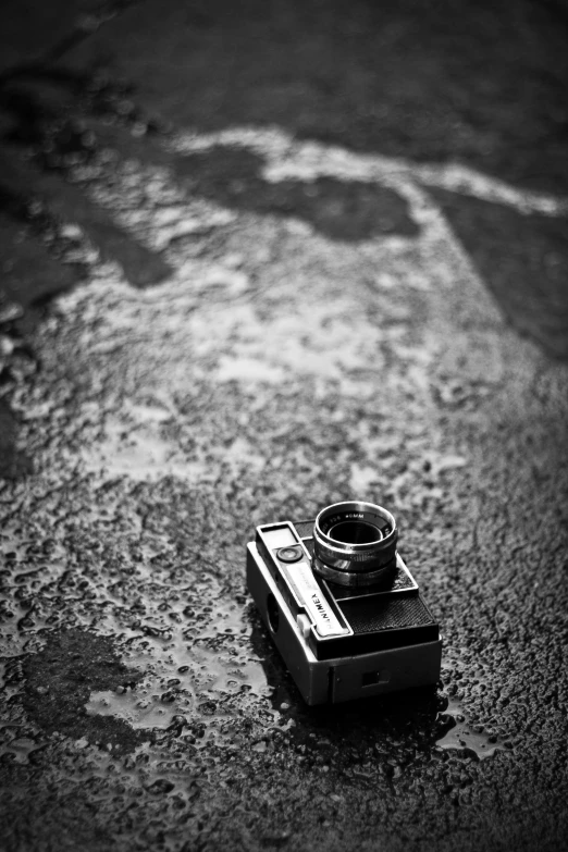 a black and white photo of an old camera, inspired by Vivian Maier, just after rain, hasselblad film bokeh, top down perspecrive, !!! colored photography