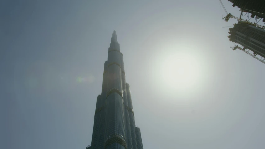 a tall building sitting in the middle of a city, inspired by Mike Winkelmann, pexels contest winner, volumetric sun rays and dust, minarets, real engine 5 cinematic, gta : dubai