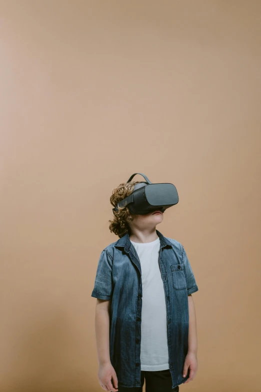 a young boy wearing a virtual reality headset, by Carey Morris, pexels, hypermodernism, plain background, trending on unreal engine 5, a boy made out of gold, school class
