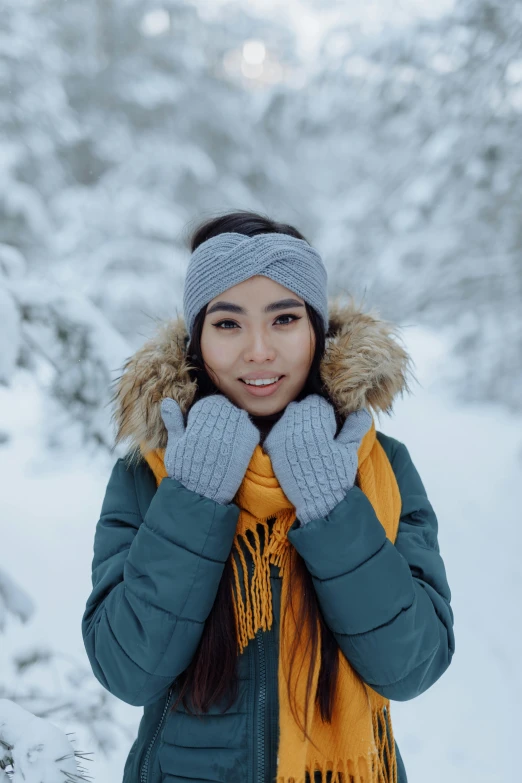 a woman is posing for a picture in the snow, trending on pexels, teal headband, grey orange, asian human, mittens