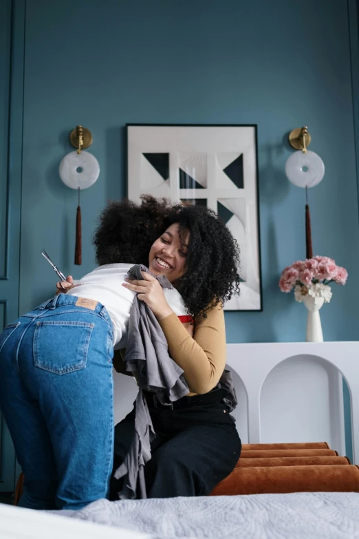 two women hugging each other on a bed, pexels contest winner, happening, in a living room, with afro, prompt young woman, praised