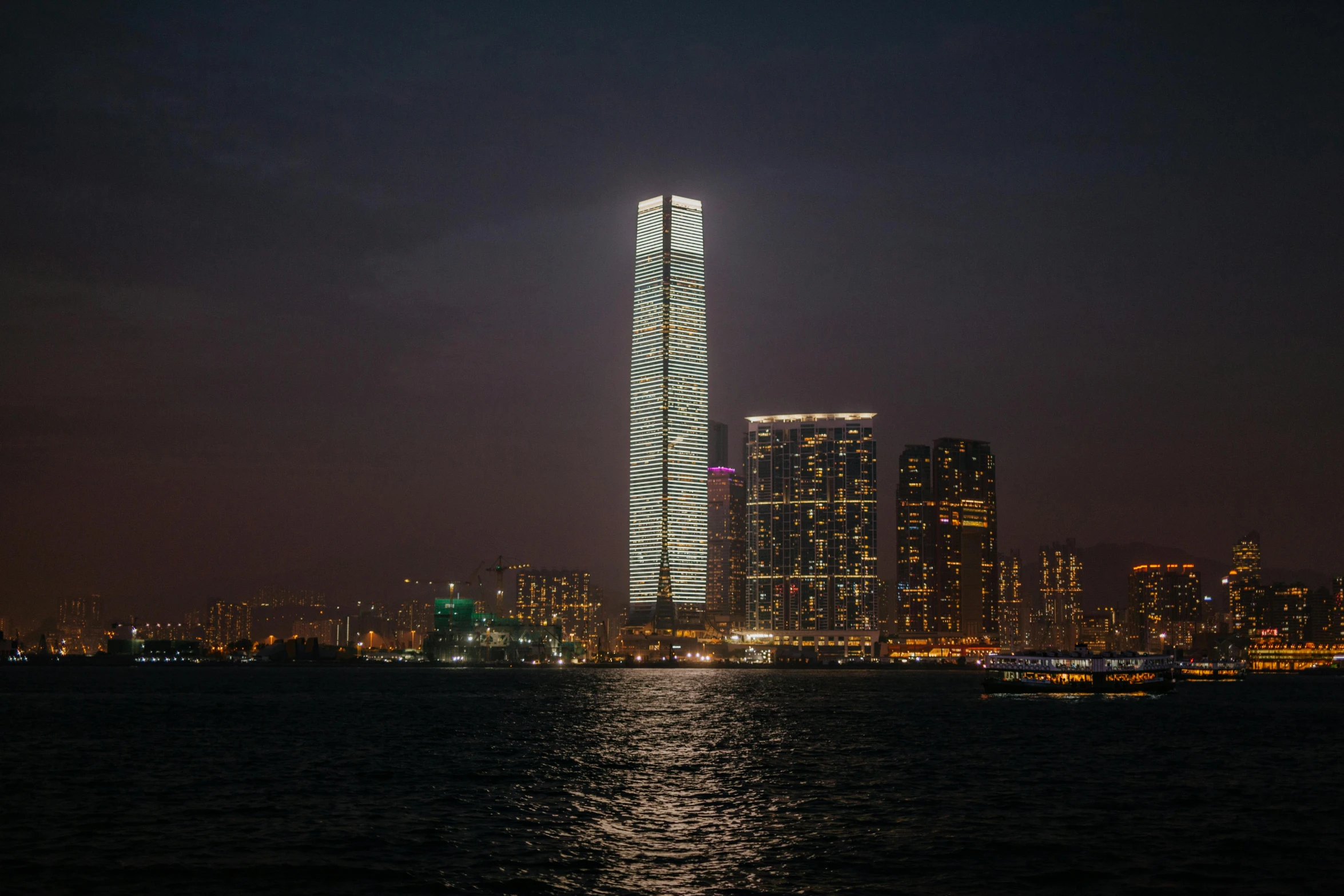 a very tall building sitting in the middle of a body of water, by Patrick Ching, pexels contest winner, herzog de meuron, low-light, the building is a skyscraper, long chin