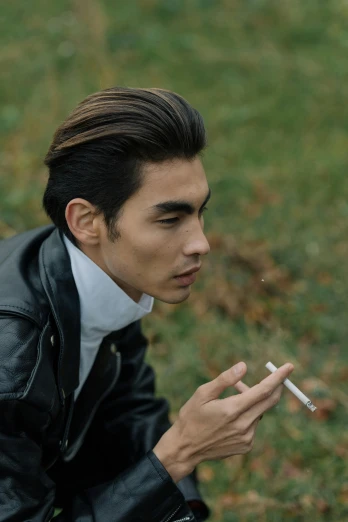 a man in a leather jacket smoking a cigarette, inspired by Jean Malouel, trending on pexels, japanese model, ignant, al fresco, strong jawline
