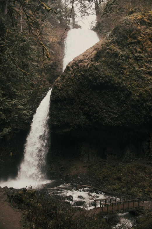 a person standing in front of a waterfall, grainy photograph, steep cliffs, portland oregon, ultrawide cinematic