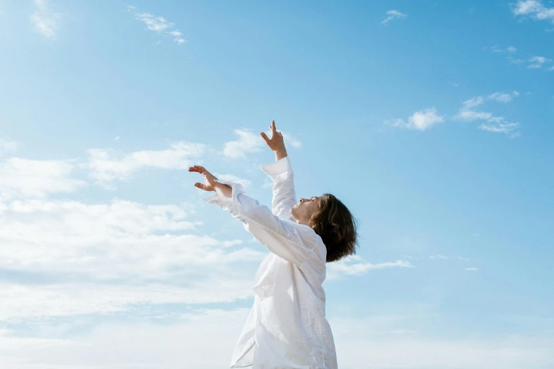 a woman standing on top of a sandy beach, unsplash, figuration libre, wearing lab coat and a blouse, reaching towards the heavens, clear blue sky, little kid