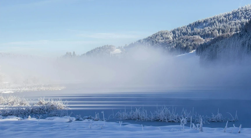 a man riding skis down a snow covered slope, by Harry Haenigsen, pexels contest winner, romanticism, in a foggy lake, a photo of a lake on a sunny day, white steam on the side, outside winter landscape