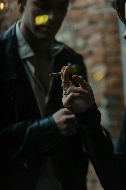 a man and a woman standing next to each other, a picture, inspired by Elsa Bleda, trending on pexels, thin soft hand holding cigarette, ignant, wearing jacket, edmund blair and charlie bowater