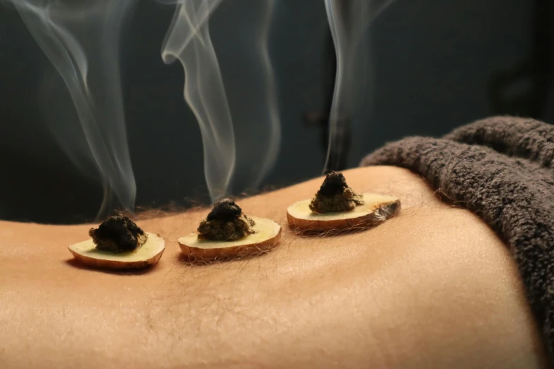 a close up of some food on a person's arm, massurrealism, smokey burnt envelopes, healing pods, lower back, spa