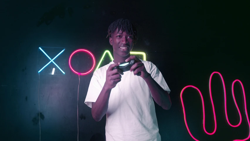 a man holding a video game controller in front of a neon sign, pexels contest winner, chief keef, kodak color, shot in the photo studio, black teenage boy