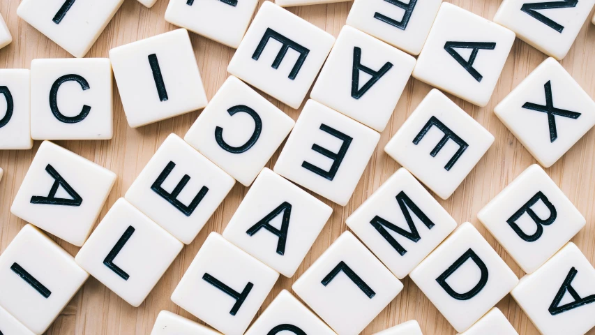 a pile of scrabbles sitting on top of a wooden table, by Emma Andijewska, unsplash, letterism, white, avatar image, background image, miscellaneous objects