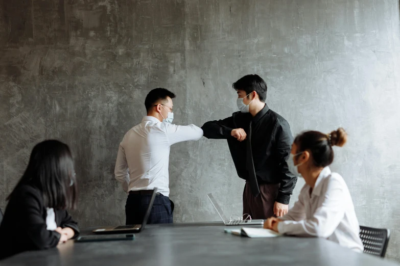 a group of people standing around a conference table, pexels contest winner, renaissance, fighting posture, asian male, two men hugging, masked person in corner