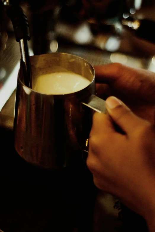 a person is making a cup of coffee, by Lee Loughridge, in a bar, milk, shiny gold, promo image