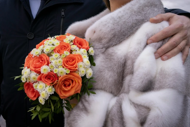 a close up of a person holding a bouquet of flowers, wearing a luxury fur coat, orange grey white, in russia, bride and groom