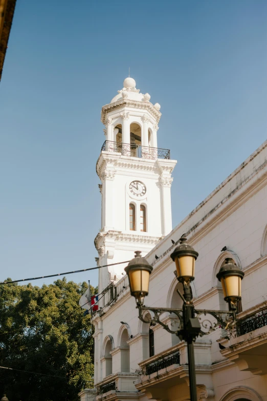 a large white building with a clock tower, by Alejandro Obregón, trending on unsplash, tlaquepaque, gas lamps, square, neoclassical tower with dome