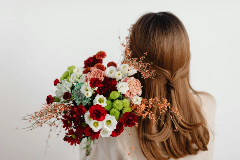 a woman is holding a bouquet of flowers, a still life, by Carey Morris, trending on unsplash, back of the hair, red brown and white color scheme, brown red long hair, arched back