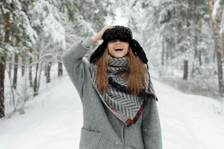 a woman that is standing in the snow, hat covering eyes, laughing, instagram post, beautiful nordic woman