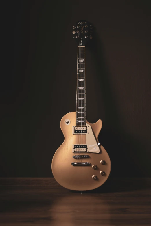 a guitar sitting on top of a wooden floor, by Gavin Nolan, pexels contest winner, photorealism, elegant gold body, miniature product photo, playing a gibson les paul guitar, plain background