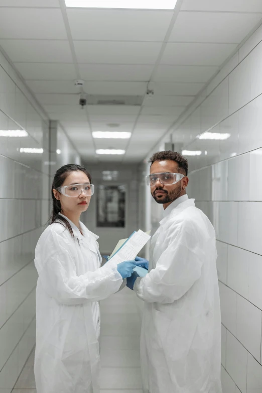 two people in lab coats standing next to each other, pexels contest winner, dystopian feel, maintenance, wearing gloves, asian man