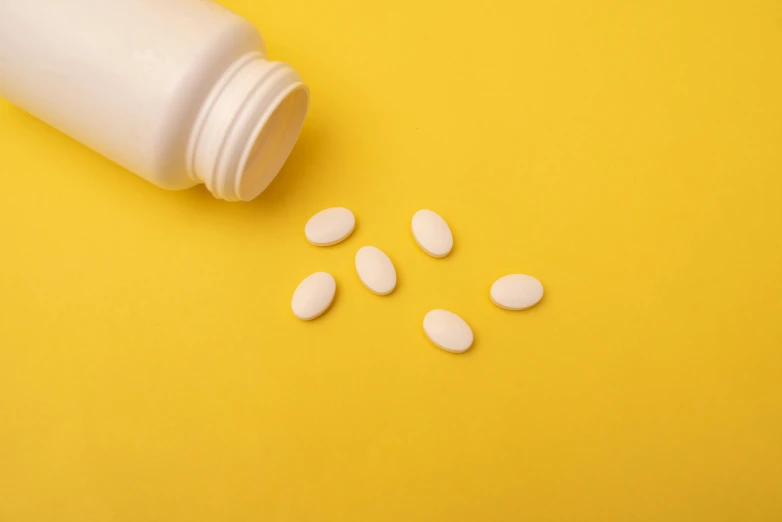 pills spilling out of a bottle on a yellow background, by Jeanna bauck, trending on pexels, antipodeans, soft white rubber, shoulder, white, sheild