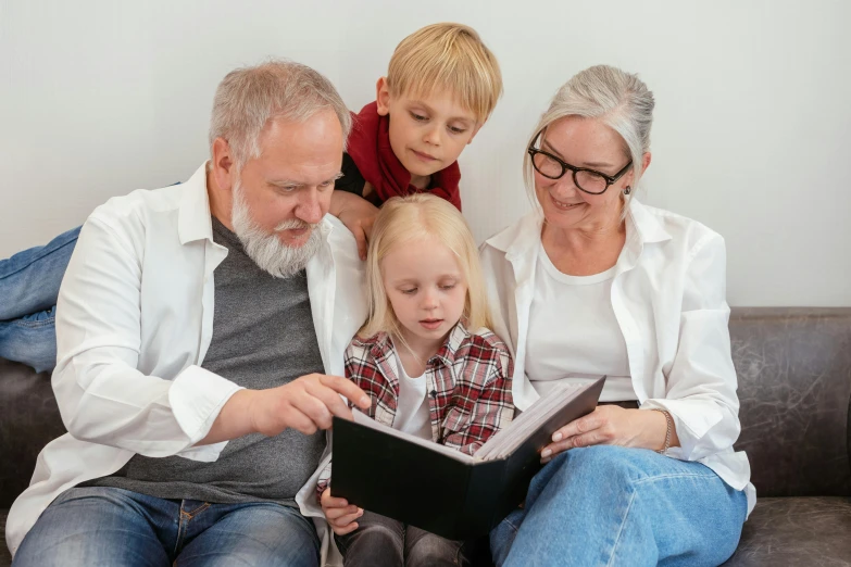 a family sitting on a couch looking at a book, pexels, visual art, local conspirologist, avatar image, an oldman, cute photo