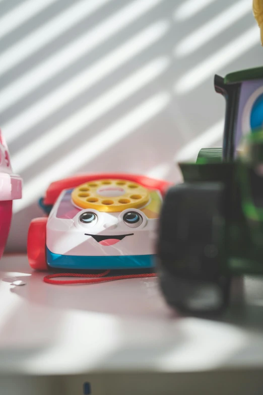 a couple of toys sitting on top of a table, a picture, upclose, vehicles, telephone, vibrant