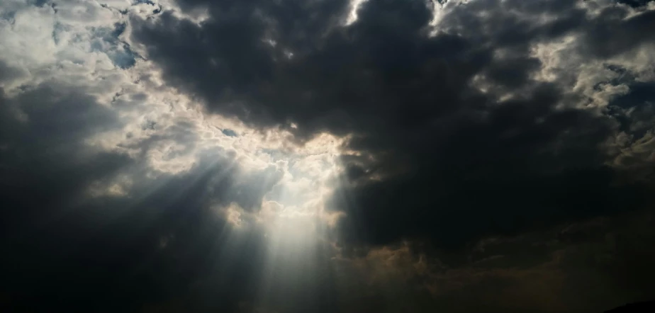 the sun is shining through the clouds in the sky, by Adam Pijnacker, pexels contest winner, light and space, grim and gloomy lighting, black clouds, angelic light, dramatic lighting 4k