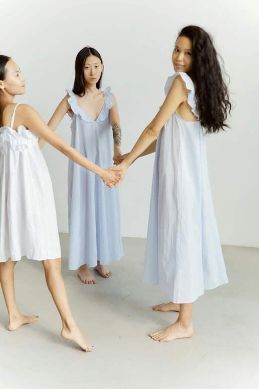 a group of young women holding hands in a circle, by Eizan Kikukawa, unsplash, gutai group, wearing a nightgown, soft blue tones, japanese collection product, home