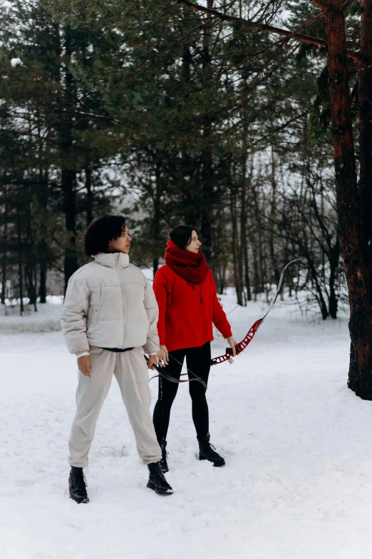 a couple of people that are standing in the snow, woman holding recurve bow, 2019 trending photo, in a park, gif