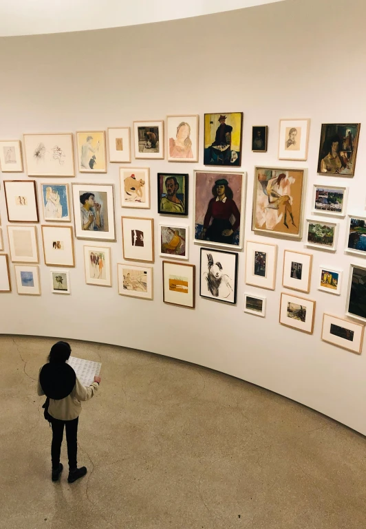 a woman standing in front of a wall full of pictures, visual art, courtesy of moma, 🎨🖌️, panoramic view of girl, georgia o'keefe