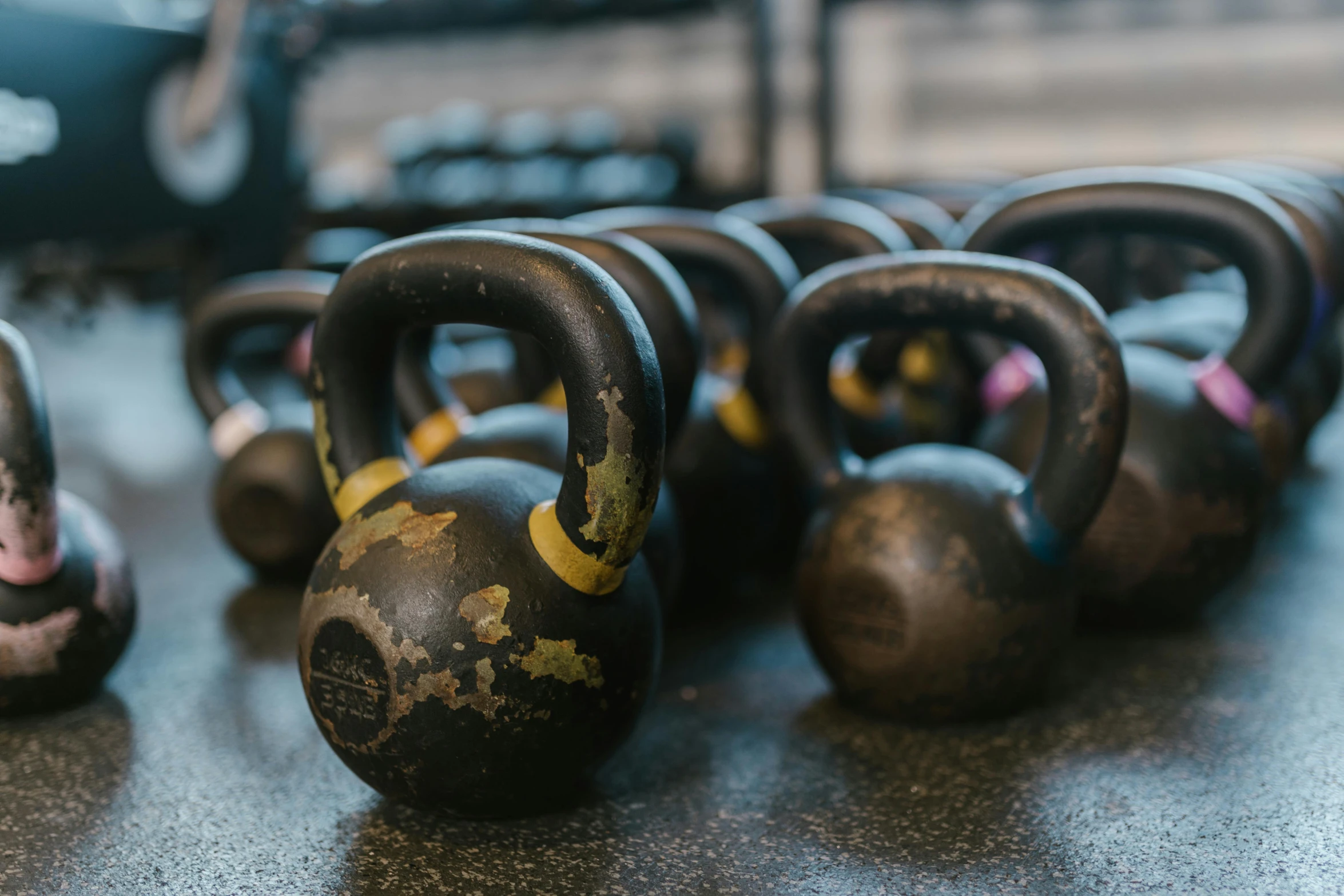 a group of kettle weights sitting on top of a table, unsplash, local gym, “ iron bark, lane brown, in shape