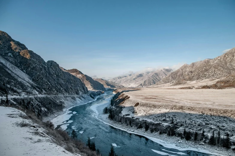 a river running through a snow covered valley, inspired by Konstantin Vasilyev, pexels contest winner, hurufiyya, baotou china, 2 0 2 2 photo, cold hues, dry river bed