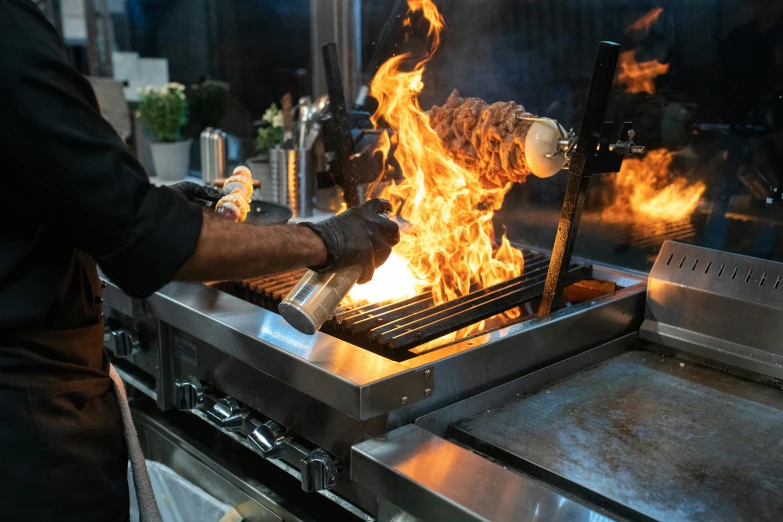 a close up of a person cooking food on a grill, the matrix servers on fire, large flames, profile image, torch lighting