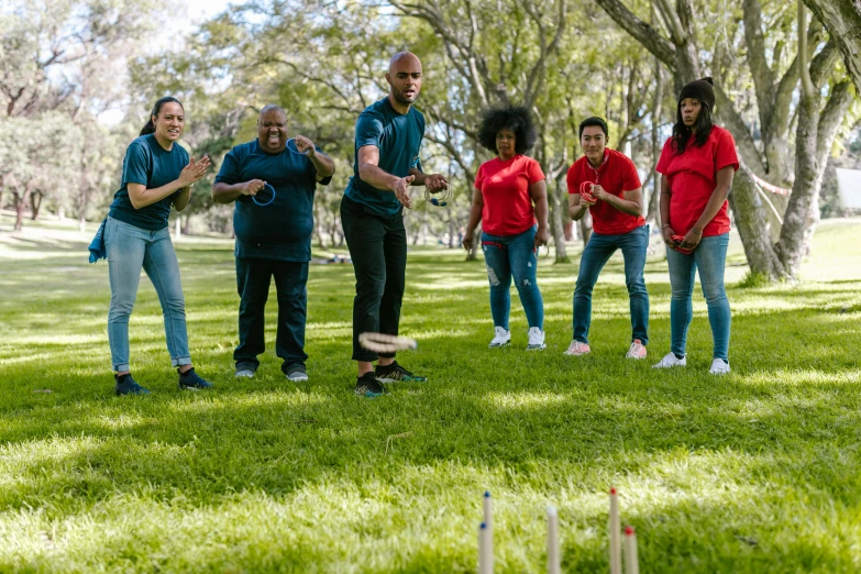 a group of people standing on top of a lush green field, playing games, keter class, promotional image, at a park