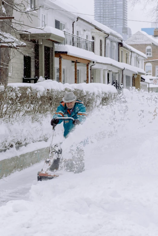 a man riding a snowboard down a snow covered street, gardening, super storm, photograph taken in 2 0 2 0, using a spade