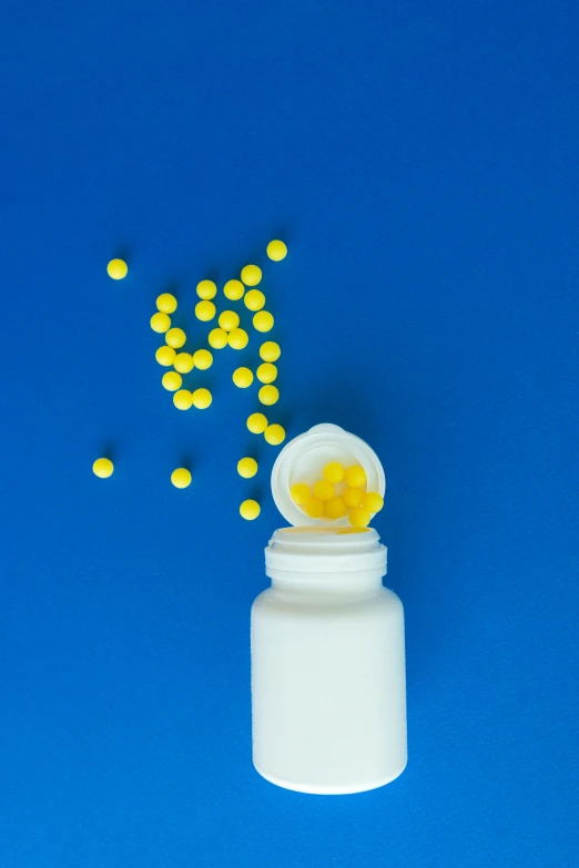 a bottle filled with yellow pills on a blue background, by Matt Cavotta, pexels, puddle of milk, synthetic bio skin, thumbnail, 2995599206