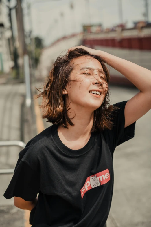 a young man standing on the side of a road, trending on unsplash, happening, portrait androgynous girl, wearing a black!! t - shirt, asian women, winking