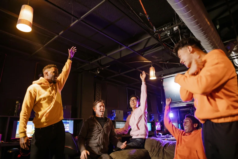 a group of people standing and sitting in a room, playing games, dabbing, blacklight reacting, on set
