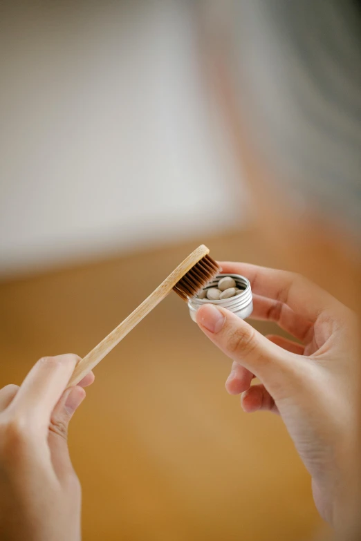 a woman brushes her teeth with a toothbrush, by David Simpson, unsplash, renaissance, made of bamboo, seeds, holding a tin can, close-up product photo