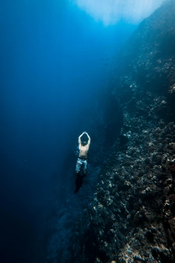 a person swimming in a body of water, by Daniel Seghers, unsplash contest winner, mariana trench, climbing, bali, solid background