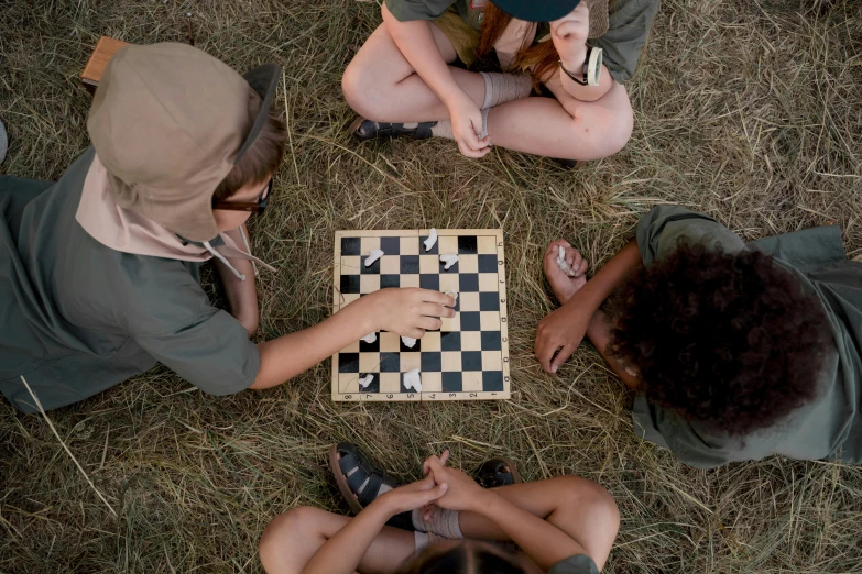 a group of people playing a game of chess, by Jessie Algie, unsplash contest winner, boy scout troop, forest picnic, slide show, ignant