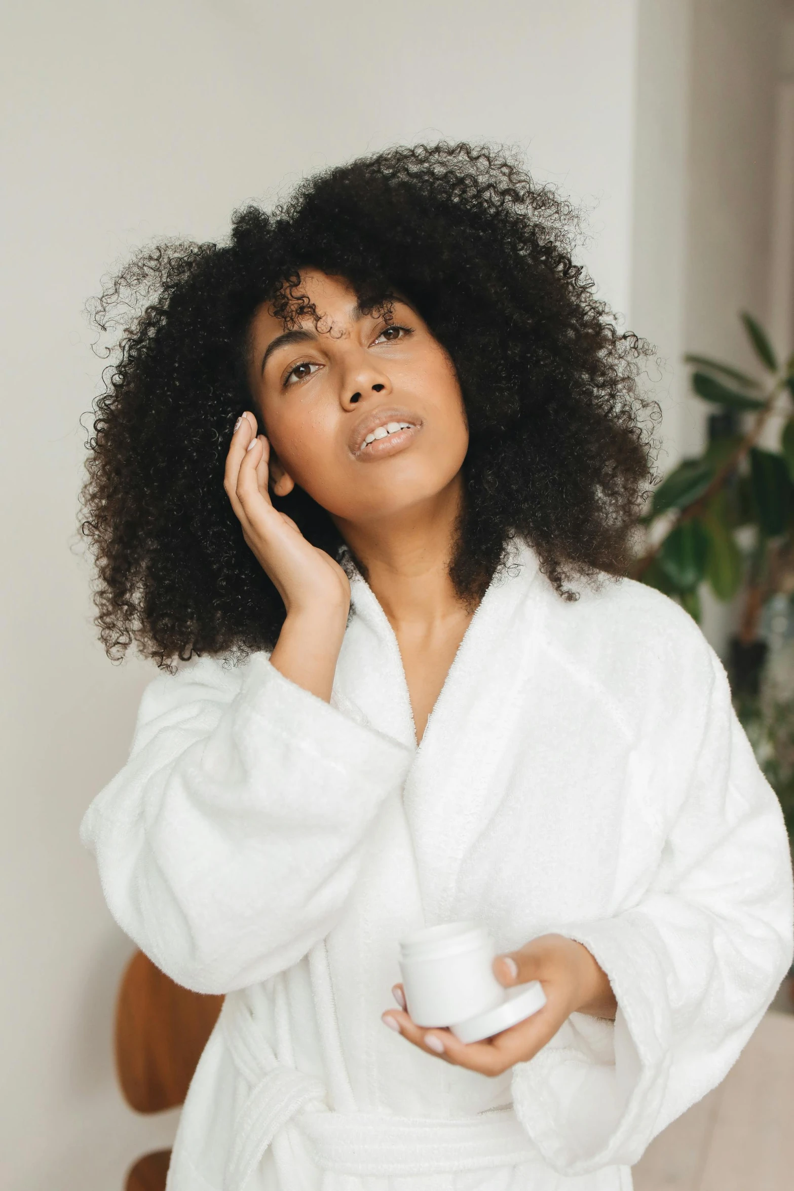 a woman in a bathrobe talking on a cell phone, trending on pexels, renaissance, long wild black curly hair, photoshoot for skincare brand, mixed race, tired face