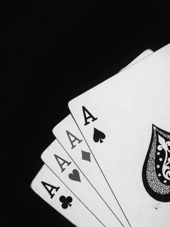 a black and white photo of four of a kind of playing cards, by Adam Chmielowski, black!!!!! background, thumbnail, acids, online casino logo