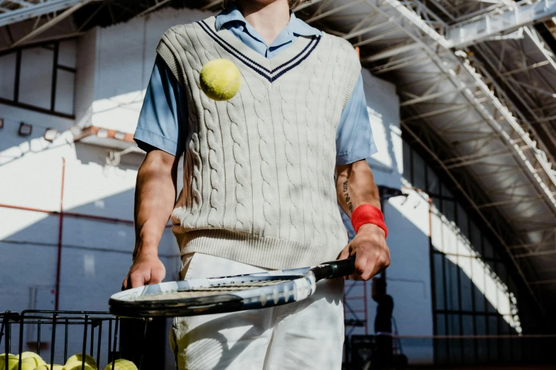 a man holding a tennis racket and a tennis ball, wes anderson style, academic clothing, federation clothing, wearing a vest