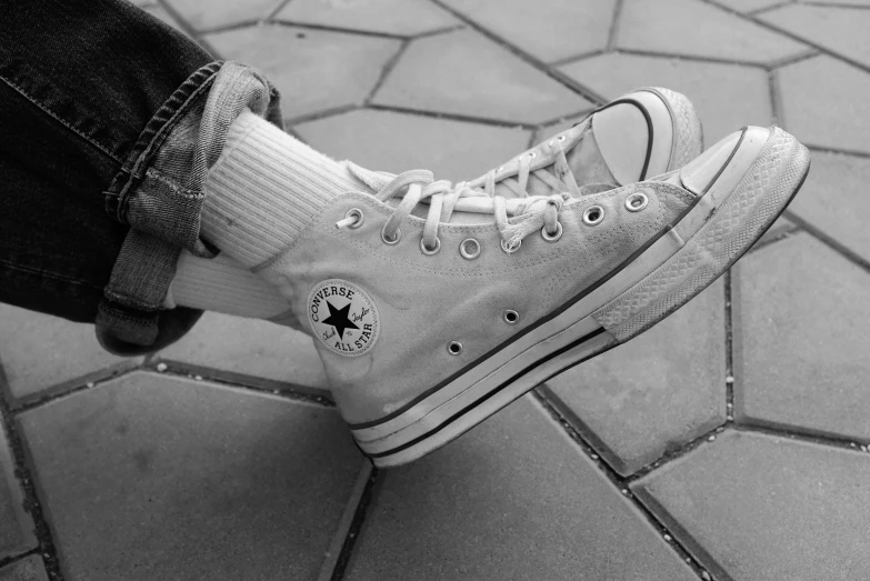 a black and white photo of a person's shoes, a black and white photo, pexels, photorealism, blue jeans and grey sneakers, in pastel shades, ❤🔥🍄🌪, sitting down casually