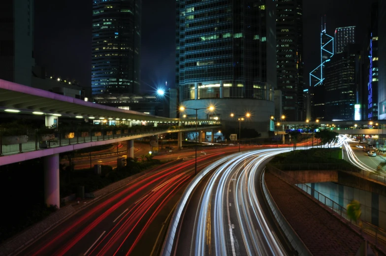 a city street filled with lots of traffic next to tall buildings, by Patrick Ching, pexels contest winner, technological lights, freeway, curving, 2000s photo
