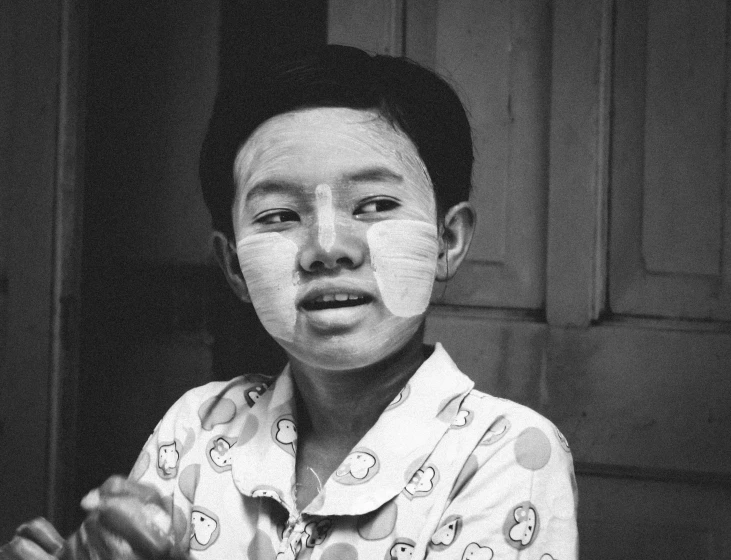 a black and white photo of a boy with tape on his face, flickr, vietnamese woman, surgery, square, old color photo