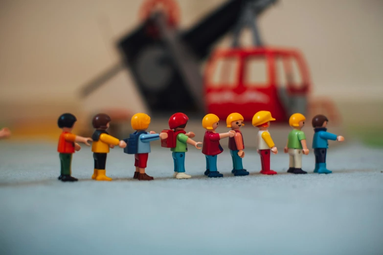 a group of toy people standing next to each other, by Romain brook, pexels contest winner, tiny ships docking, 1 9 8 0 s children's show, construction, over his shoulder