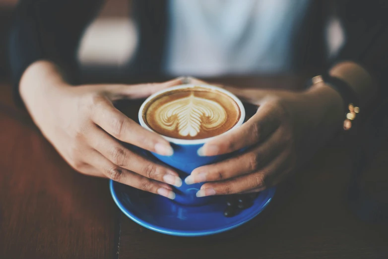 a close up of a person holding a cup of coffee, blue, avatar image, aussie baristas, beautiful image