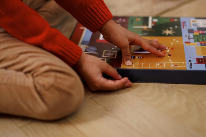 a person sitting on the floor playing a board game, inspired by Frederick Hammersley, naive art, christmas night, kids playing, subtle detailing, press shot